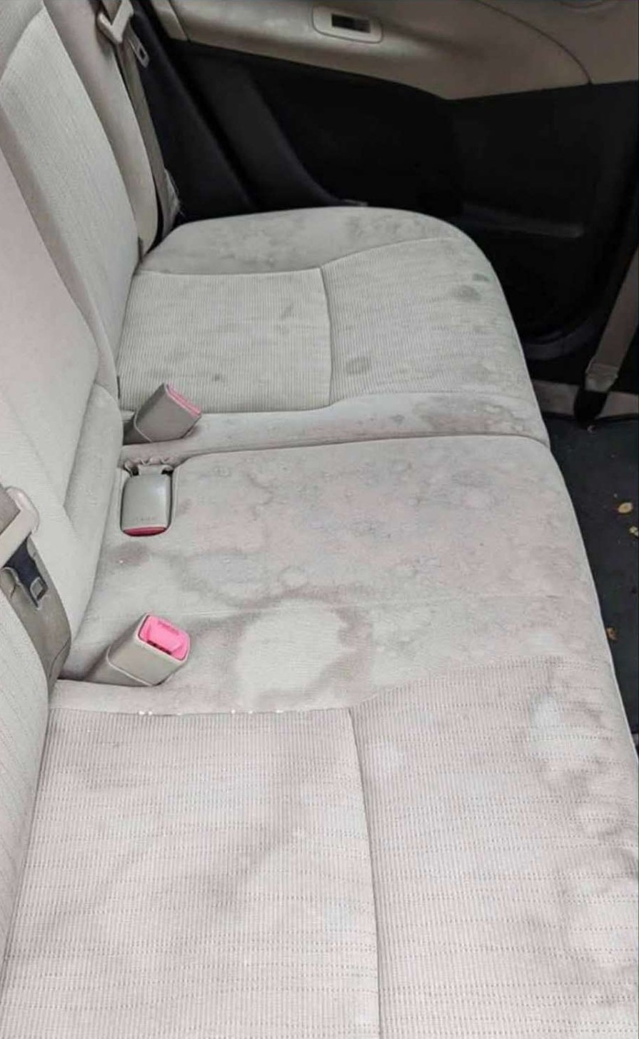 Cream car back seats covered in dirt patches and water marks