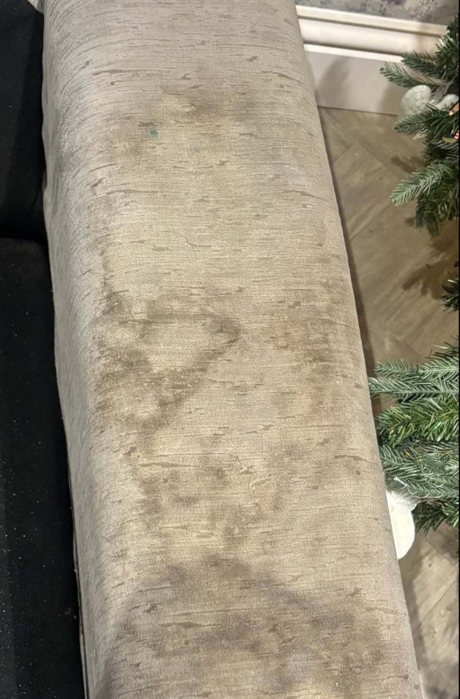 Velvet sofa arm heavily soiled with dirty patches and watermarks
